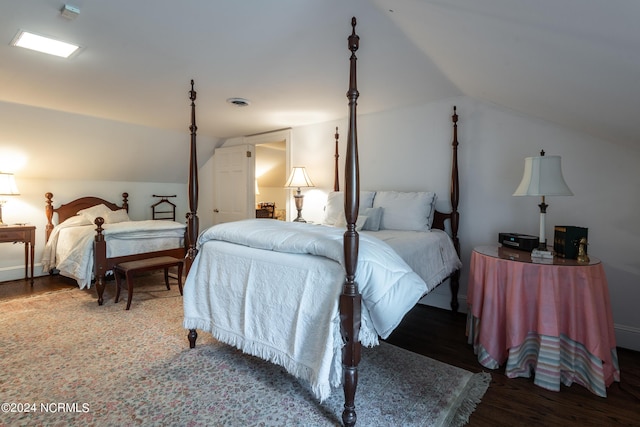 bedroom with wood-type flooring and vaulted ceiling