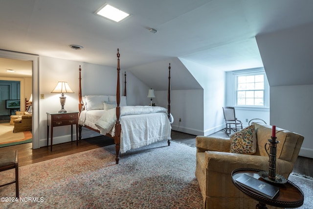 bedroom with hardwood / wood-style floors and vaulted ceiling