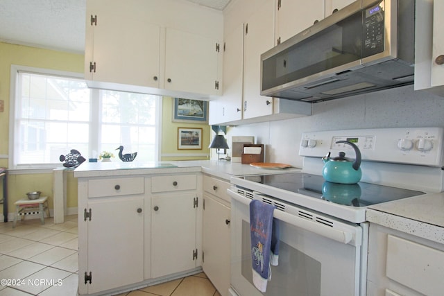 kitchen with white cabinetry, light tile patterned floors, and white range with electric stovetop