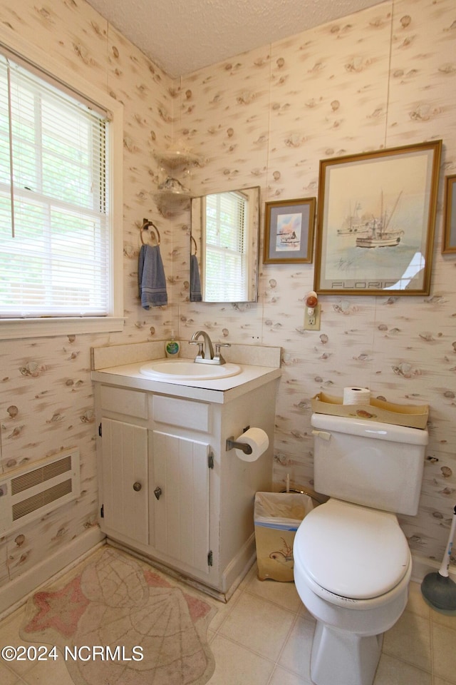 bathroom with a healthy amount of sunlight, toilet, a textured ceiling, and vanity