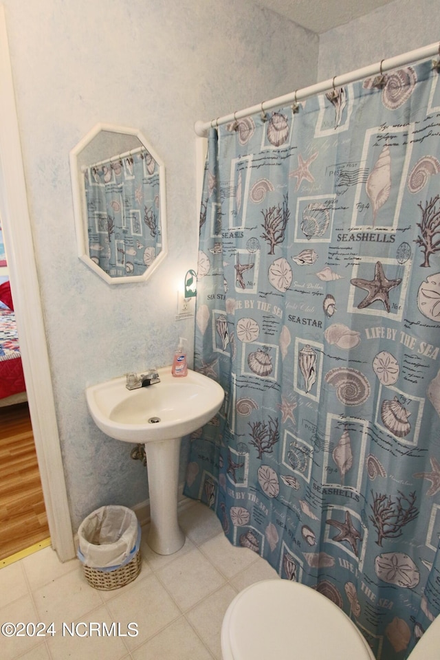 bathroom with tile patterned flooring, sink, toilet, and walk in shower