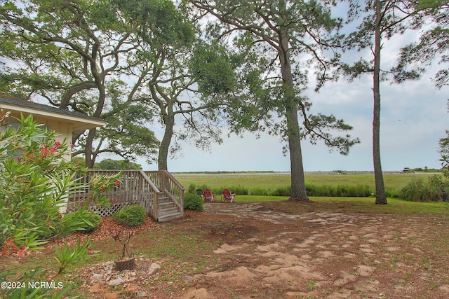 view of yard with a rural view and a deck