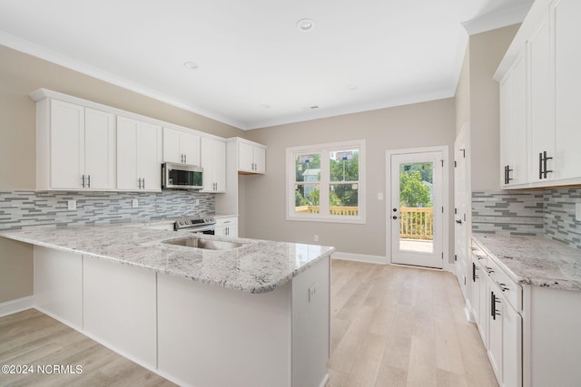 kitchen with light stone counters, decorative backsplash, kitchen peninsula, and white cabinetry