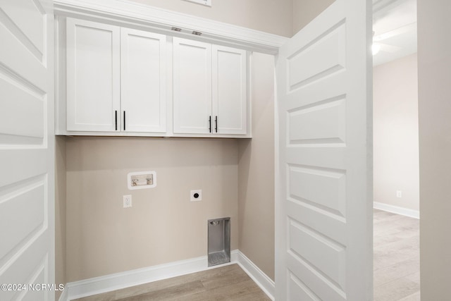 laundry room with electric dryer hookup, hookup for a washing machine, light wood-type flooring, and cabinets