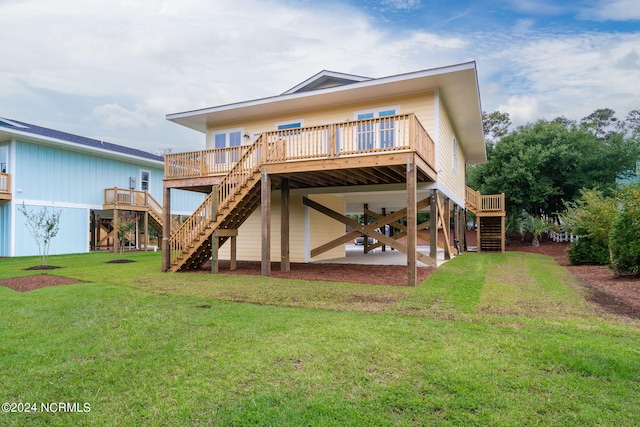 rear view of house with a wooden deck, a patio area, and a lawn