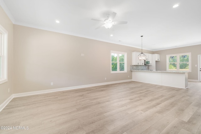 unfurnished living room featuring a wealth of natural light and light hardwood / wood-style floors