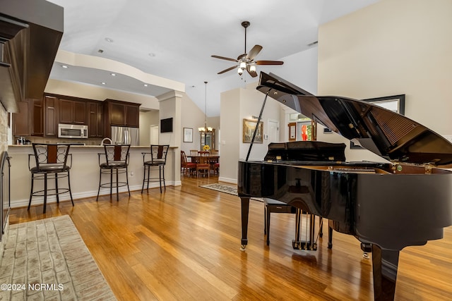 interior space with lofted ceiling, recessed lighting, light wood-style flooring, baseboards, and ceiling fan with notable chandelier