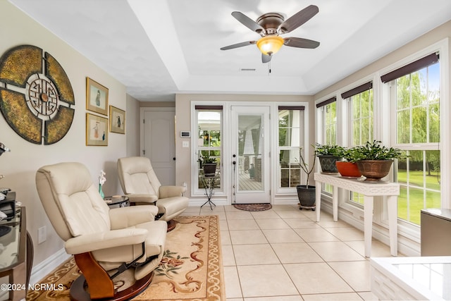 sunroom featuring a ceiling fan, a tray ceiling, and visible vents