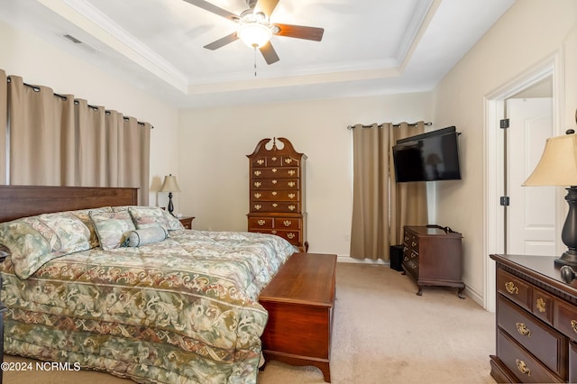 bedroom with light carpet, visible vents, a ceiling fan, ornamental molding, and a raised ceiling