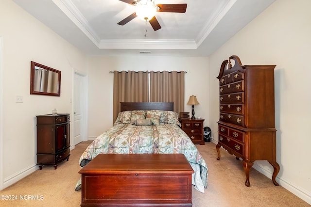 bedroom featuring ornamental molding, a tray ceiling, and light colored carpet