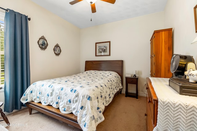 bedroom with baseboards, a ceiling fan, and light colored carpet