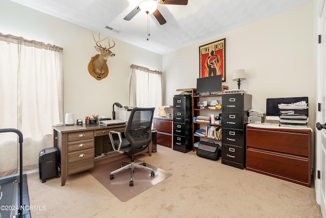 office featuring light carpet, visible vents, and a ceiling fan