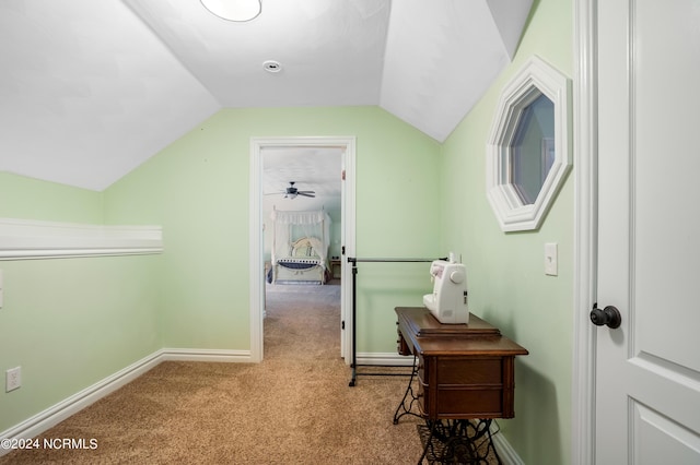 corridor featuring lofted ceiling, carpet, and baseboards