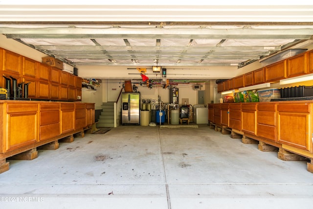 garage with washing machine and dryer and stainless steel fridge with ice dispenser