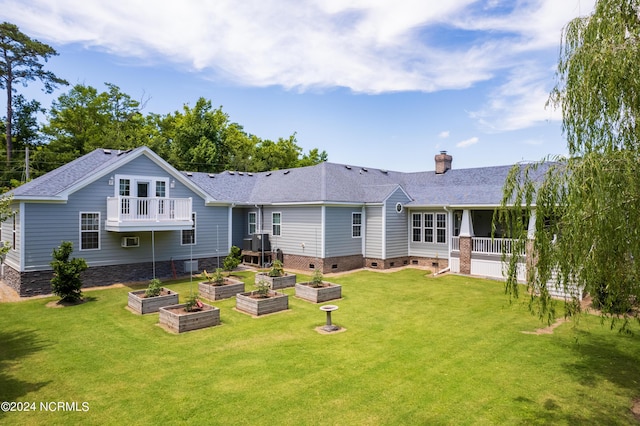 back of property with a yard, crawl space, a vegetable garden, and a chimney