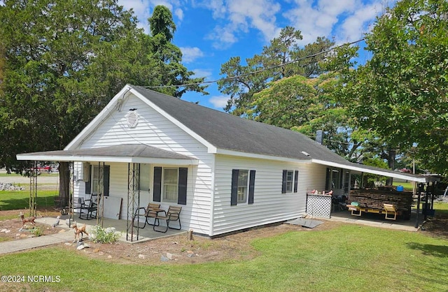 view of front of house featuring a porch, roof with shingles, and a front yard