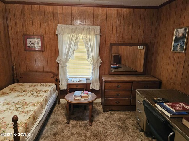 bedroom featuring wood walls and dark carpet