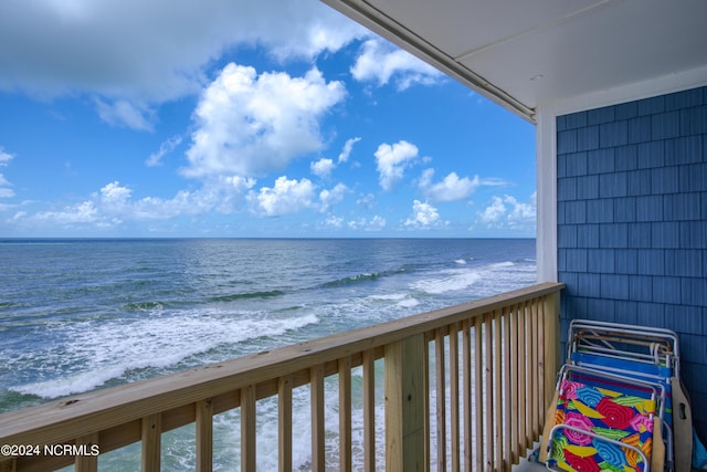 balcony with a water view and a beach view