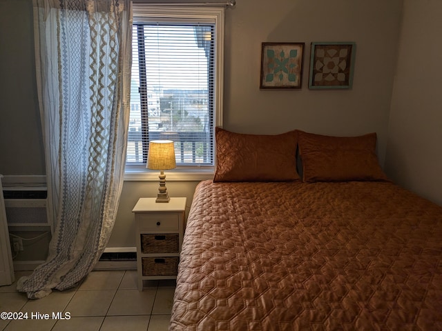 bedroom with cooling unit, a baseboard heating unit, and light tile patterned flooring