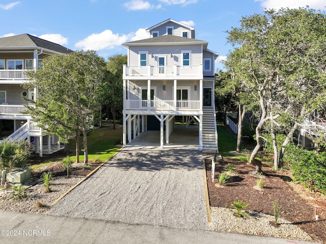 coastal inspired home featuring a porch, a carport, and a balcony