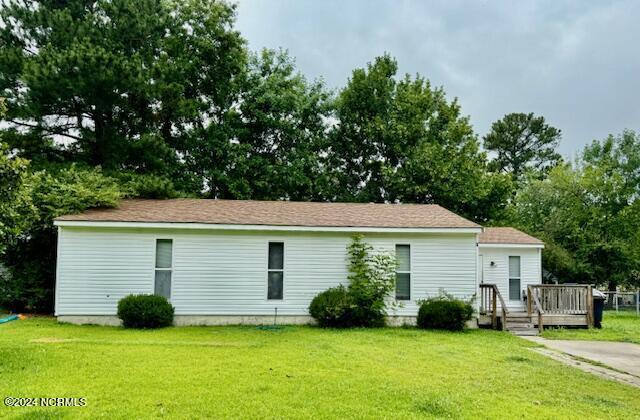 back of house featuring a wooden deck and a lawn