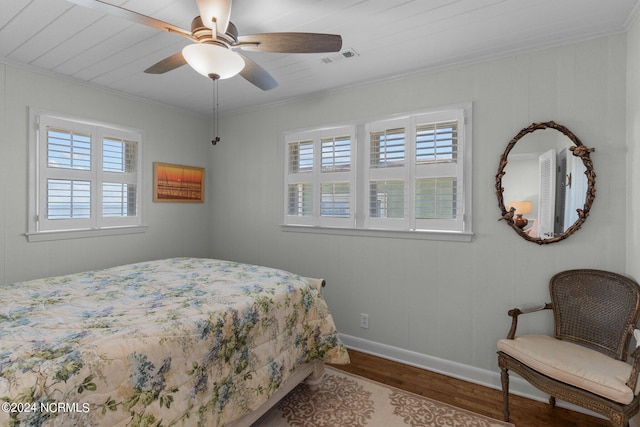 bedroom featuring hardwood / wood-style floors, ceiling fan, and crown molding