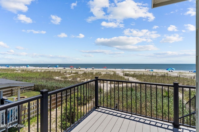 deck with a view of the beach and a water view