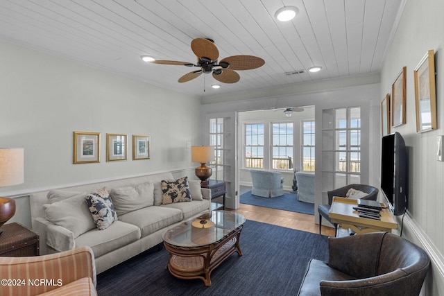 living room with ceiling fan, wood-type flooring, wooden ceiling, and crown molding