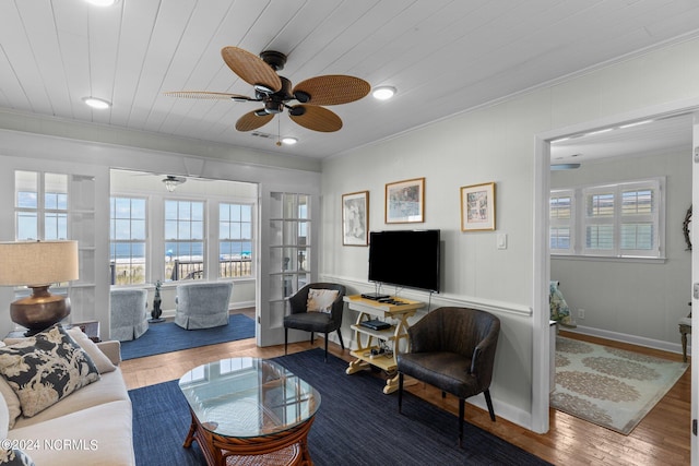 living room featuring a healthy amount of sunlight, wood-type flooring, wooden ceiling, and ornamental molding