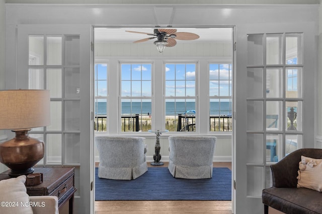 interior space with a water view, ceiling fan, and hardwood / wood-style flooring