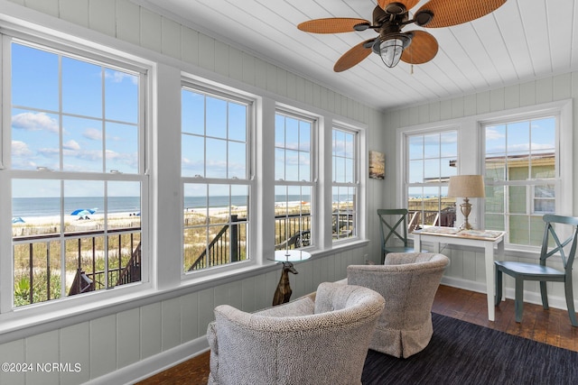 sunroom / solarium with ceiling fan, a water view, wood ceiling, and a beach view