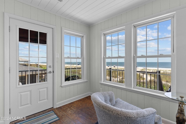 sunroom / solarium with a water view and a beach view