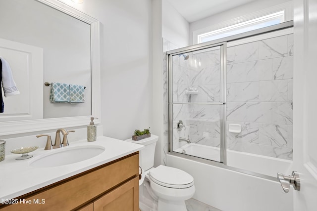 full bathroom featuring bath / shower combo with glass door, vanity, and toilet