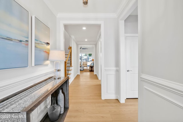 hallway with ornamental molding and light wood-type flooring