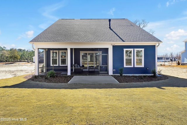 back of property featuring a sunroom and a lawn