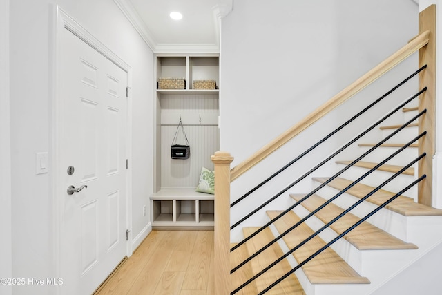 mudroom featuring ornamental molding and light wood-type flooring