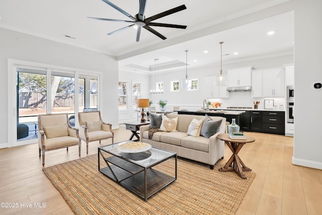 living room featuring ornamental molding, sink, ceiling fan, and light hardwood / wood-style floors