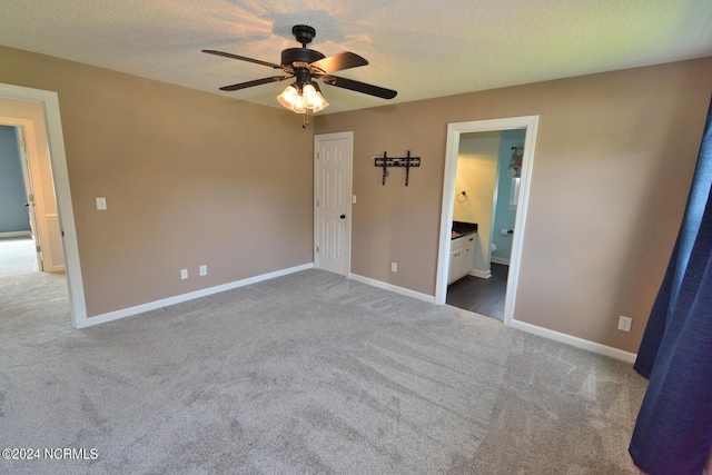 unfurnished bedroom featuring connected bathroom, ceiling fan, carpet, and a textured ceiling