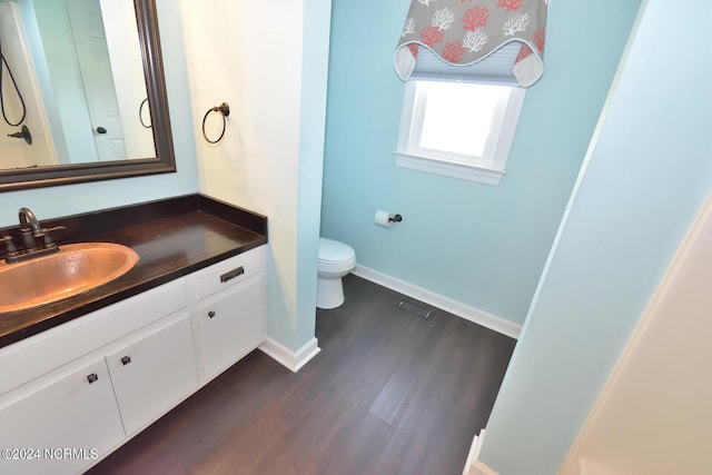 bathroom featuring vanity, wood-type flooring, and toilet