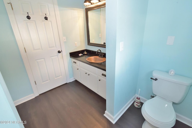 bathroom with hardwood / wood-style flooring, vanity, and toilet