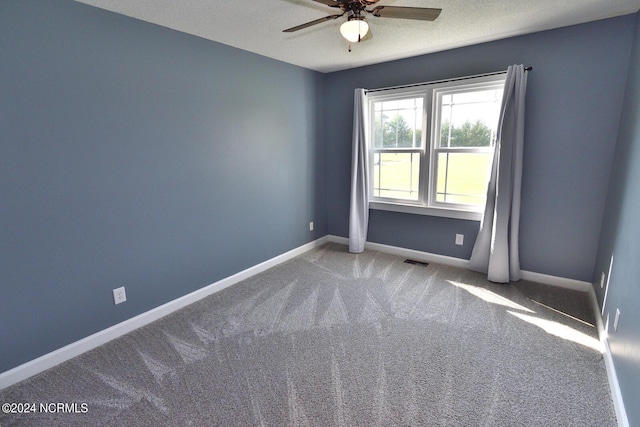 unfurnished room with ceiling fan, carpet, and a textured ceiling