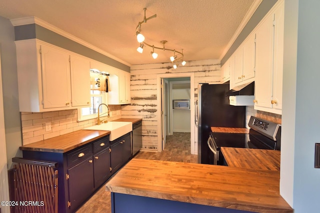 kitchen with a textured ceiling, stainless steel appliances, sink, white cabinets, and butcher block countertops