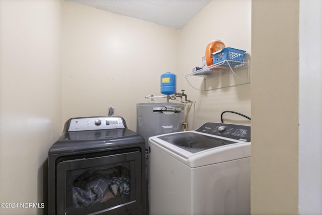 laundry room featuring a textured ceiling, electric water heater, and separate washer and dryer