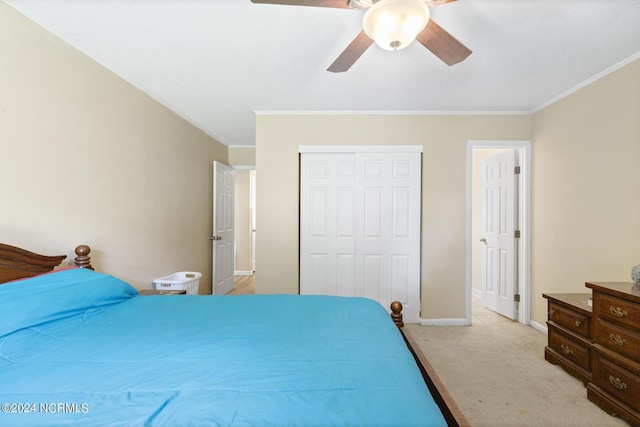 carpeted bedroom featuring ceiling fan, a closet, and crown molding