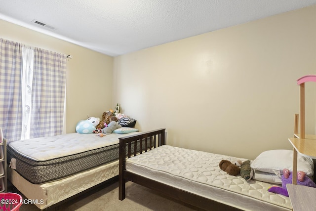 carpeted bedroom with a textured ceiling