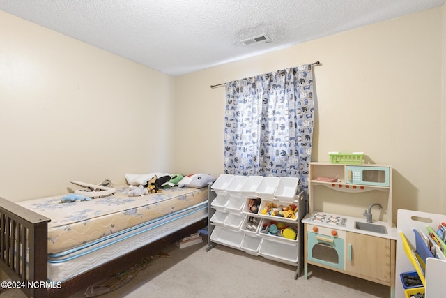 carpeted bedroom featuring a textured ceiling