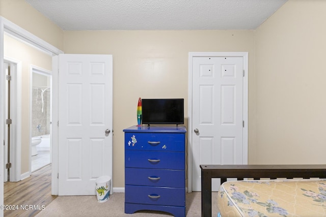 bedroom featuring ensuite bathroom and a textured ceiling