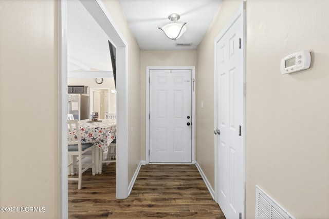 corridor featuring a textured ceiling and dark hardwood / wood-style floors