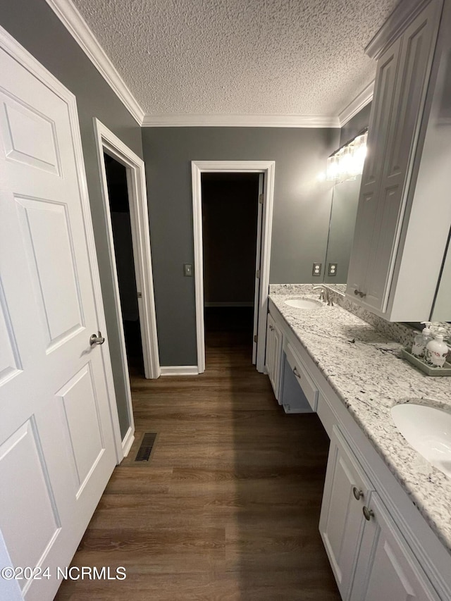 bathroom featuring vanity, a textured ceiling, hardwood / wood-style flooring, and crown molding