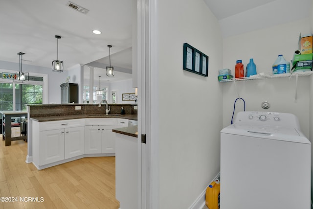 washroom with washer / clothes dryer, sink, and light hardwood / wood-style floors